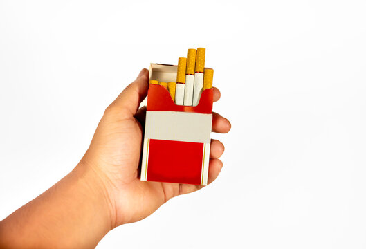 Person holding red pack of cigarettes in hand with cigarette addiction nicotine unhealthy lifestyle dangerous commercial