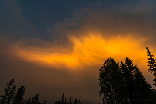 Canada, BC, 70 Mile House, Green Lake.  The sun illuminates smoke in the sky during nearby wildfire.