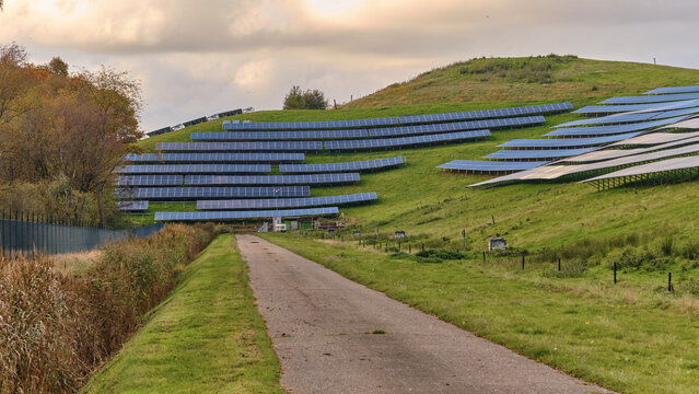 Wijster, Netherlands - 27 October 2024: View of solar panels installed on the grassy slopes of the VAM-berg landfill hill under a cloudy sky.