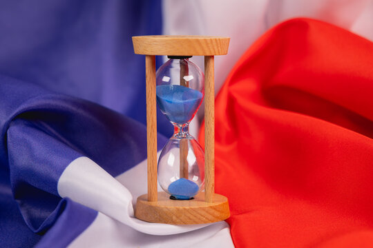 Un sablier pos&eacute; sur le drapeau de la France, symbolisant un compte &agrave; rebours. 