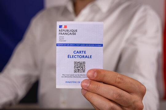Une personne pr&eacute;sentant sa carte &eacute;lectorale pour aller voter. 30 juin 2026 - Paris, France