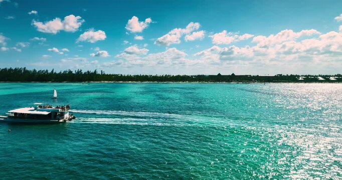 Panoramic view of a tourist excursion cruise boat cruising along the tropical coastline of Saona island, summer trip from Punta Cana, Dominican Republic