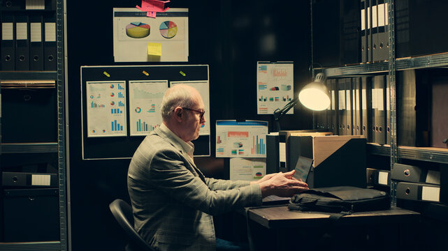 Senior investigator studying archive folders for case similarities, looking for incriminating evidence during legal inquiry, law enforcement agent reading federal classified notes.