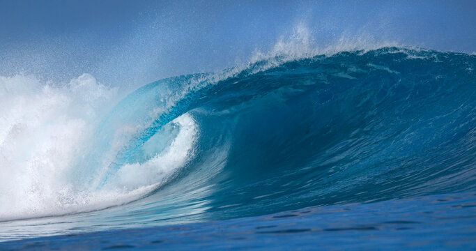 CLOSE UP: Flawless barrel wave wraps into a glowing blue cylinder as white spray lifts off the lip. Classic reef break in the Mentawai Islands, full of tropical color and pure power of Indian Ocean.