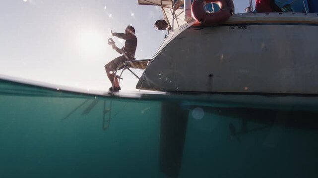Freediving from the yacht. Freediver prepares for diving in the sea from sailing boat