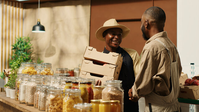 Local farmer bringing freshly harvested goods to vendor, working on supplying zero waste eco store, contractor restocking fruits and veggies at supermarket, gives boxes of products.