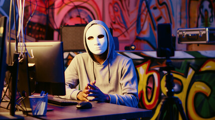 Anonymous masked dissident hacker filming anti government message, fighting against propaganda,...