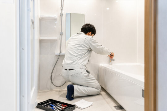 浴室の水栓を修理する作業員