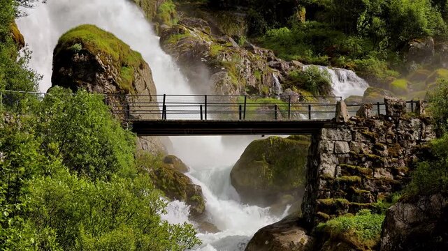 Bridge over the Kleivafossen waterfall on the way to Brikdalsbreen Glacier in Norway.