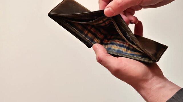 empty wallet.lack and shortage of money.A mans hands open an empty wallet against a light background.Budget deficit and poverty concept.4k footage