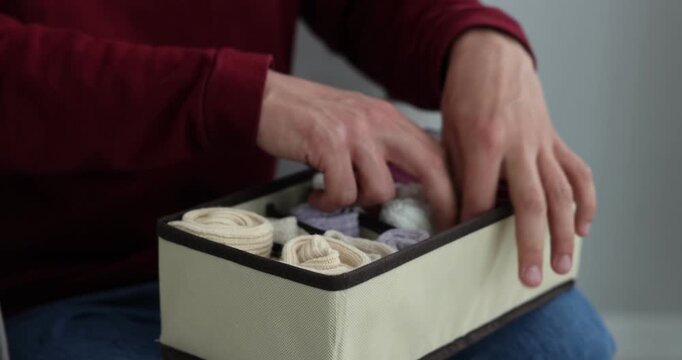 Man putting socks into organizer at home, closeup