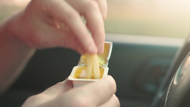 Hand Dipping French Fries into Curry Sauce Close Up Inside Car | Fast Food Snack on Road Trip Static Shot