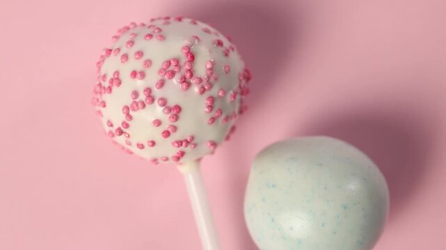 Tasty cake pops on pink background, top view