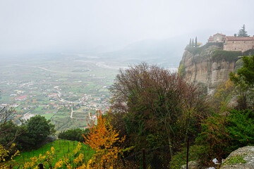 The 14th century Holy Monastery of St. Stephen (Agios Stefanos) perched on a sandstone cliff on a foggy autumn day in Meteora, Greece