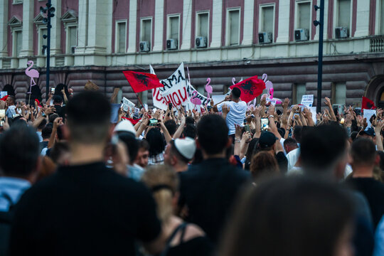 Tirane, Albania - 03 June 2026: View of a large crowd of protesters gathered in front of a government building holding Albanian flags and banners during a public demonstration.