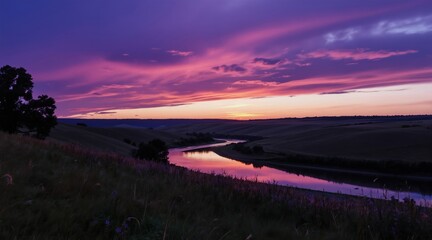 Fototapeta premium Winding river reflects vibrant purple pink sunset sky over rolling hills and wildflower meadow. Peaceful twilight landscape offers serene natural beauty and calm atmosphere.