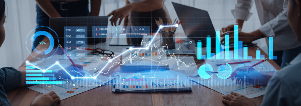 A professional team engages in financial analysis, utilizing digital graphs and charts to interpret data insights in a modern office environment, enhancing decision-making. Scalp