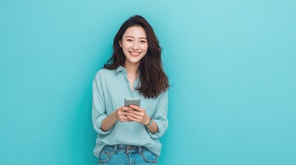 Obraz premium Smiling young woman with smartphone on blue background