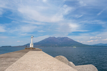 突堤と灯台の先に桜島を望む鴨池港の風景 © tanoji