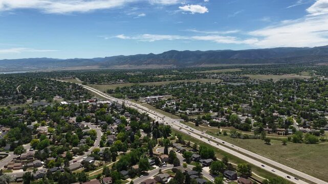 Wide Aerial of suburban landscape in Littleton Colorado in summer with highway 285 and mountain view