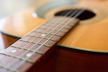 Fototapeta premium Close up of acoustic folk guitar strings and soundhole with wooden body