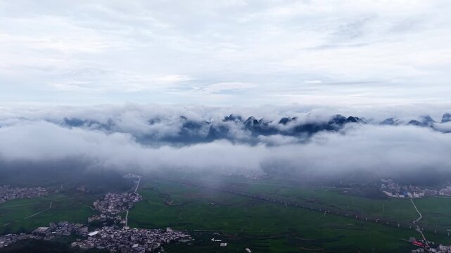 Aerial of Karst Mountains, Cloud Sea, Green Rice Paddies and Village in the Valley