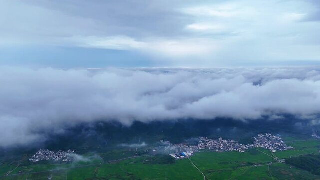  Cloud Sea Over Karst Peaks, Green Rice Fields and Village in Valley Below, Aerial