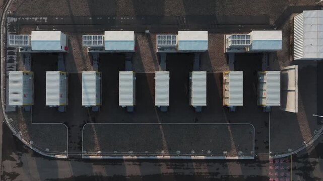 Aerial view of energy storage battery arrays installed on industrial factory rooftops