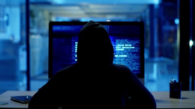 Phishing Scam Cyber Criminal Back View Coding Spyware Malware and Viruses at Night in 4K Ultra HD footage
