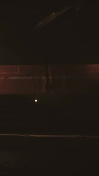 A train travels through a tunnel in the dark of night. Bright lights shine from the front of the train, illuminating parts of the tunnel. The scene shows a sense of motion and movement.