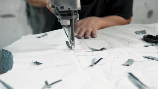 Textile Factory Workers Cut Massive Layers of China Fabric Using Industrial Tool. Garment Manufacturing Material Patterns Cutting Stage. Cheap Labor Mass Production Line Close-up Shot 4k