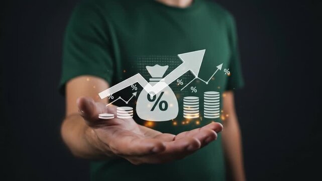 A person holds out their palm, presenting a glowing infographic symbolizing financial growth, investment, and profit. The graphic features a money bag with a percentage sign, stacks of coins.