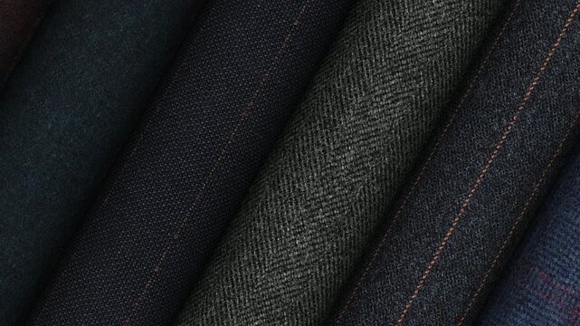 Luxury fashion fabrics from Italy displayed in rotating rolls with rich texture refined materials and timeless elegance