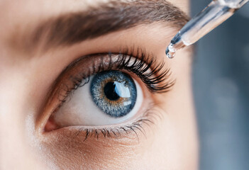 Naklejka premium Close up blue eye with dropper applying liquid drop iris pupil