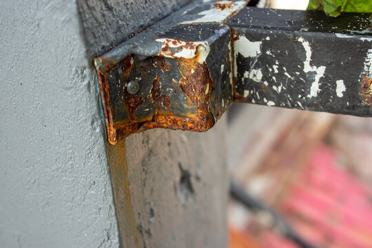 Close Up of Rusted Metal Bracket Attached to Concrete Wall Showing Corrosion and Weather Damage