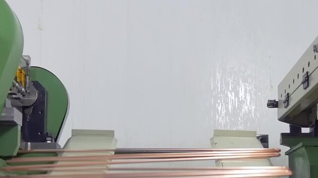 Watch as advanced machinery skillfully shapes metal rods into elegant components. This process showcases the precision and efficiency of modern technology, set in a bright, industrial workspace.