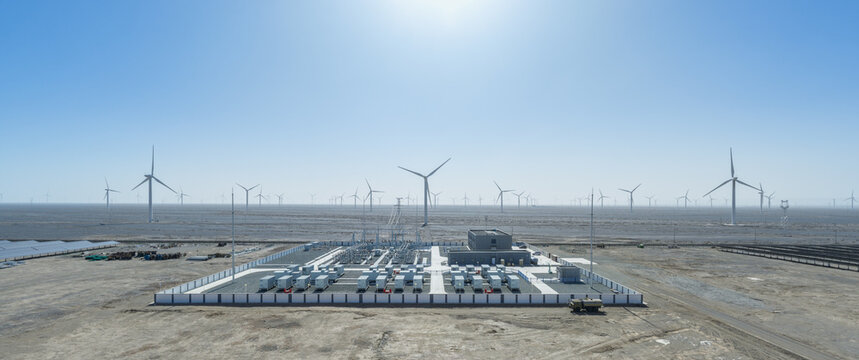 Grid-Scale Battery Storage Facility Surrounded by Wind Turbine Array in Gobi Desert Under Bright Sun