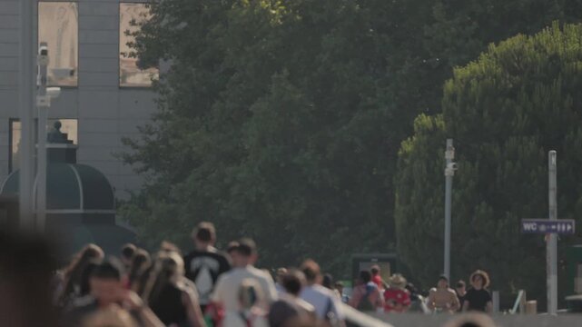 Anonymous crowd of football fans walking on a bridge