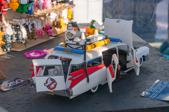 Red, white, blue Ghostbusters toy car on a blue cloth-draped table in a bustling market setting - Kyiv, Ukraine - September 21, 2025