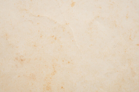 Old vintage paper texture background with aged stains and antique yellowed parchment effect