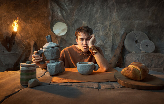 Funny Prehistoric Caveman with Stone Moka Coffee Maker in a Cave