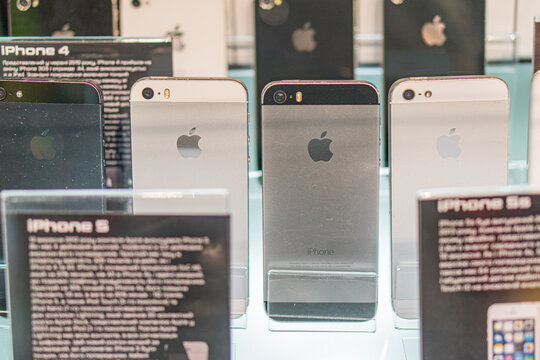 Arrangement of Apple iPhones 4 on illuminated shelves, showcasing classic black and silver design Devices display distinct serial numbers, suggesting exhibition or - Kyiv, Ukraine - September 14, 2025