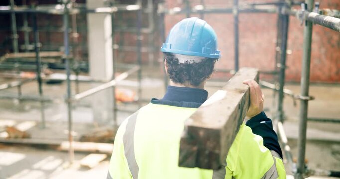Man, architect or walking with wooden plank on construction site for building material or foundation. Back view, male person or contractor with equipment for scaffolding or architecture development