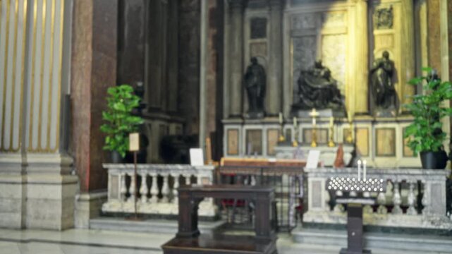 Blurred church interior with soft bokeh altar, marble balustrade and votive candles in defocused depth; background copyspace backplate.
