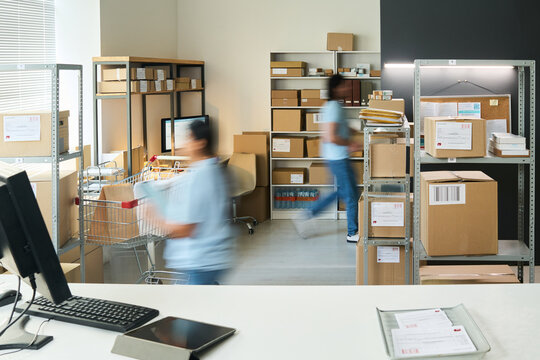 Young workers processing parcels and moving through order pickup point, managing fulfillment workflow and delivery logistics. Ideal for e commerce, shipping service, retail operations