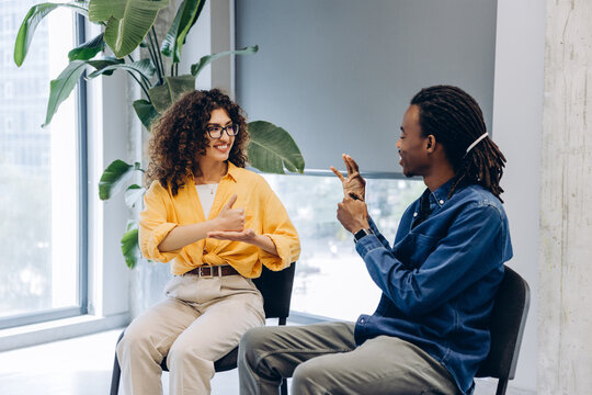 Diverse colleagues communicating using sign language in office