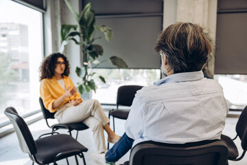 Obraz premium Psychotherapist discussing with man during support group session