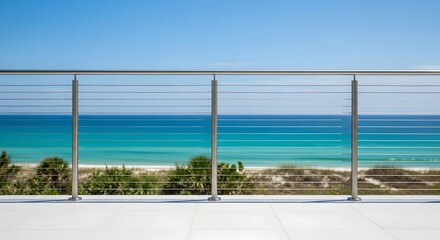 Fototapeta premium Modern cable railing balcony overlooking a beautiful turquoise ocean and sandy beach.