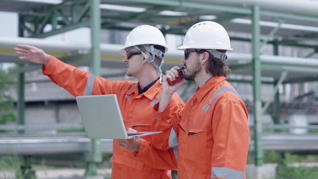 Professional engineers conduct detailed inspection of expansive industrial pipeline infrastructure outdoors utilizing laptops and safety apparel for meticulous maintenance tasks.