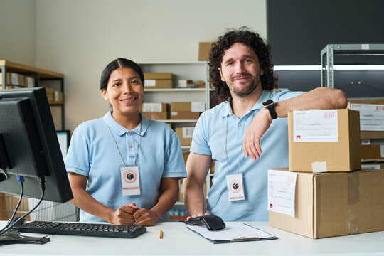 Portrait of young delivery workers standing at order pickup counter, managing parcel collection and fulfillment. Useful for e commerce logistics, shipping service marketing
